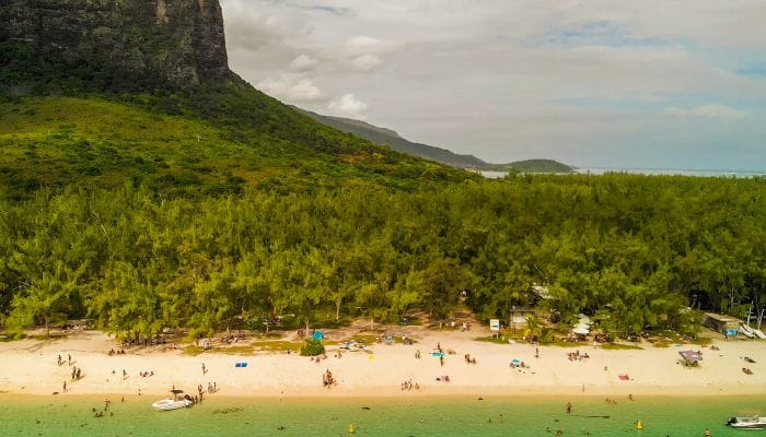 Le Morne in Mauritius, a hub for water adventures, featuring crystal-clear waters and people engaging in various water sports