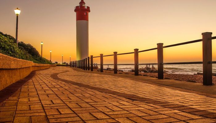 Image of Umhlanga Lighthouse: An iconic beacon standing tall against the coastline, guiding ships with its distinctive red and white structure, amidst the beauty of the sea