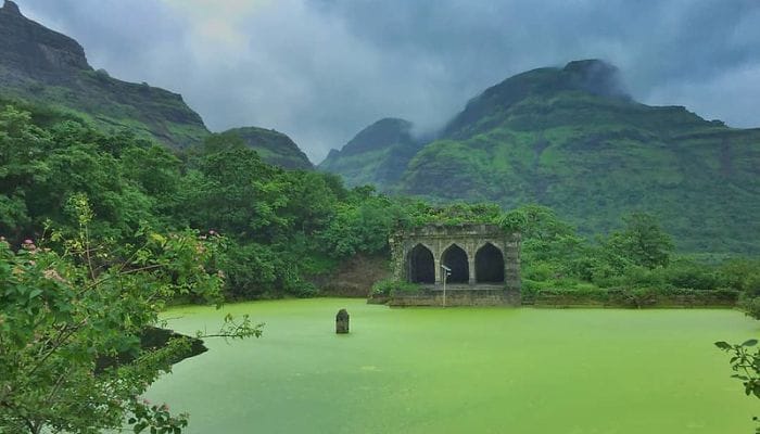 Mulher Fort Trek - A panoramic view of the trekking path leading to Mulher Fort, surrounded by lush greenery and offering glimpses of historical ruins