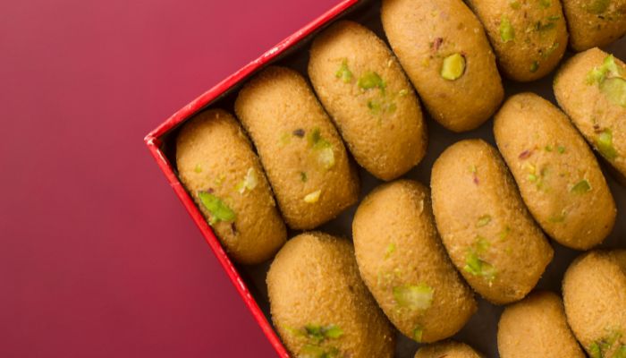 Peda, round-shaped milk-based sweets with saffron and nuts, arranged on a plate