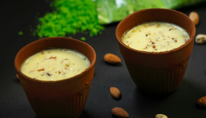 Thandai, a traditional Indian cold beverage garnished with nuts and spices, served in a glass