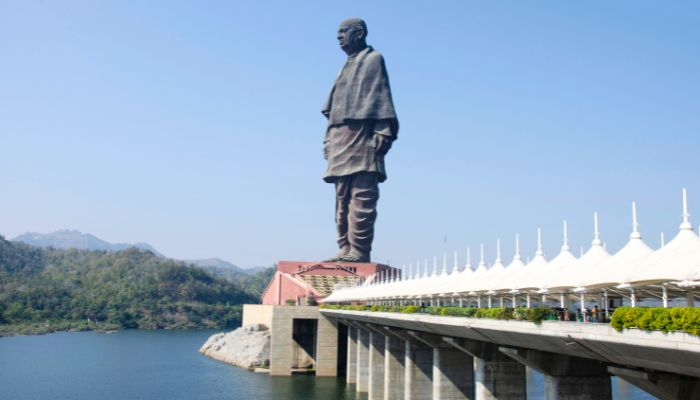 The towering Statue of Unity in Gujarat, depicting Sardar Vallabhbhai Patel, with lush green hills and the Narmada River in the background