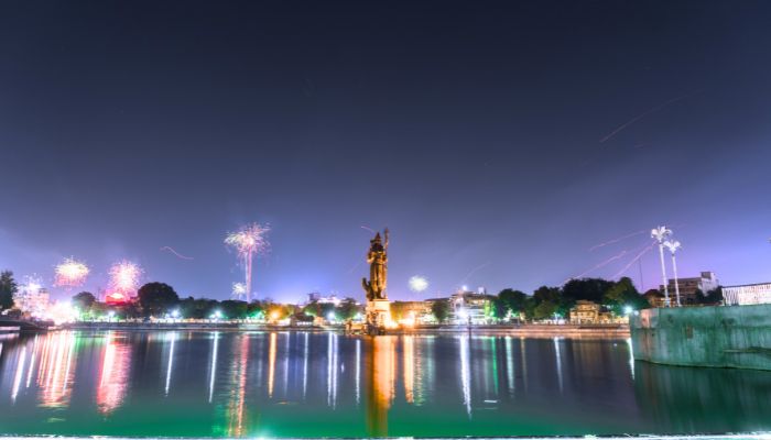 A serene view of Sursagar Lake in Vadodara, with calm waters reflecting the cityscape and the iconic statue of Lord Shiva