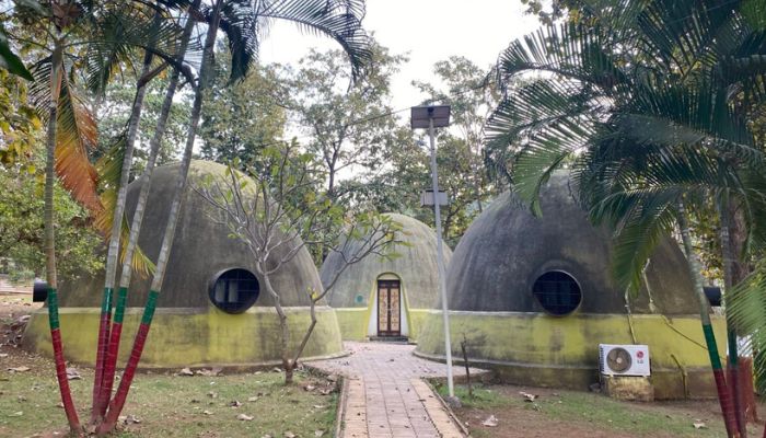 Unique dome-shaped huts surrounded by greenery at Kevdi Eco Campsite