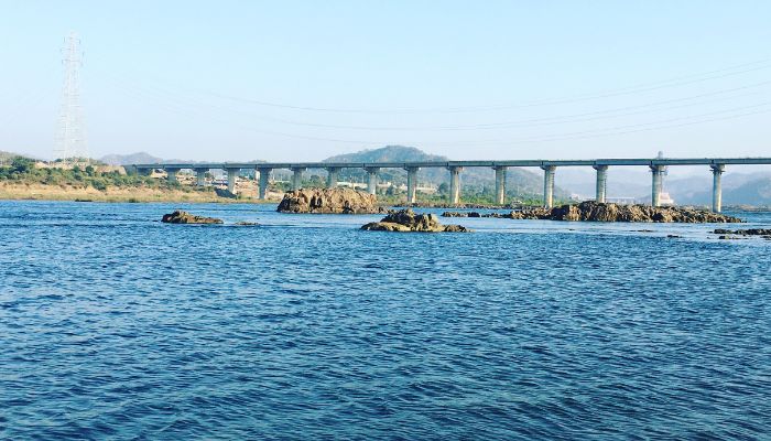 Scenic view of Narmada River Campsite with tents pitched along the riverbank, surrounded by natural beauty and flowing water